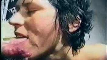 Perspiring dark-haired woman joyfully swallowing semen on webcam